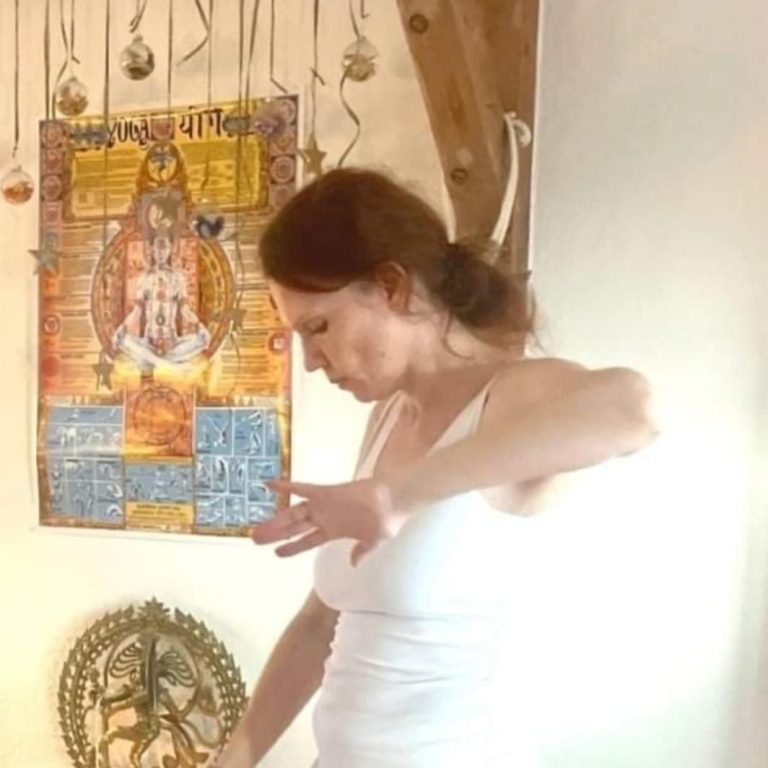 Liilia Link in einem weißem Kleid tanzend in hellem Licht